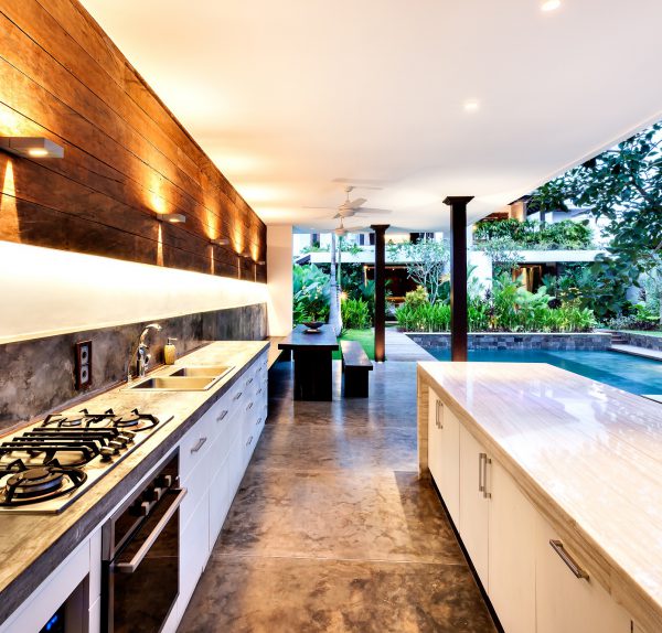 Outdoor Kitchen With A Stove An Countertop Next To Garden